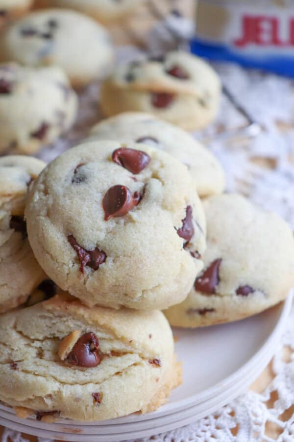 Chocolate chip cookies piled on a white plate.
