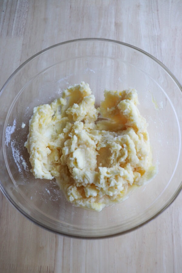 Butter and sugar creamed together in a clear glass bowl.