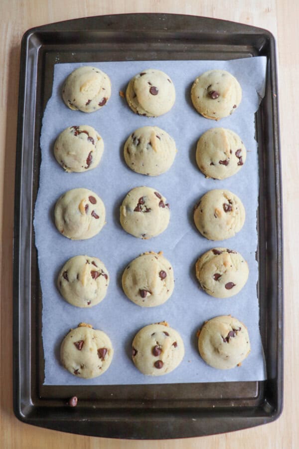 Chocolate chip cookies on a parchment paper lined cookie sheet.