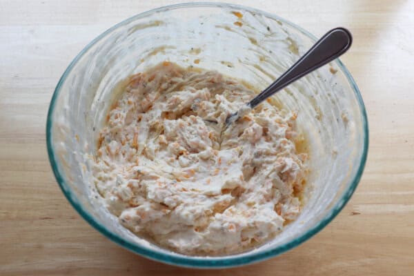 Beer ranch dip ingredients mixed in a medium clear class bowl.