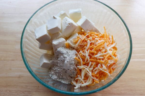 Beer ranch cheese dip ingredients in a medium clear glass bowl.