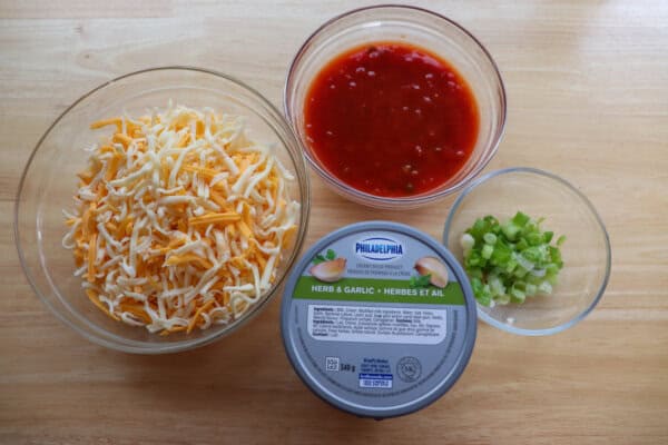 Salsa Cheese Dip in clear glass bowls on a wooden table.
