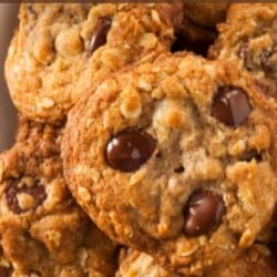 Oatmeal chocolate chip cookies on a wooden cutting board.