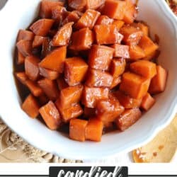 Sweet potatoes covered in a brown sugar glaze in a large white bowl.