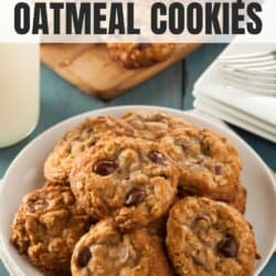 Oatmeal chocolate chip cookies stacked on a white plate.