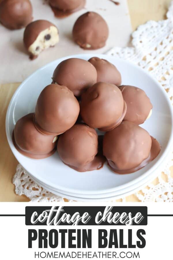Cookie dough balls with chocolate coating in a stack on a white plate.