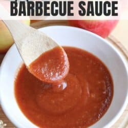 Apple bourbon BBQ sauce in a small white bowl with a wooden spoon dipping into it.