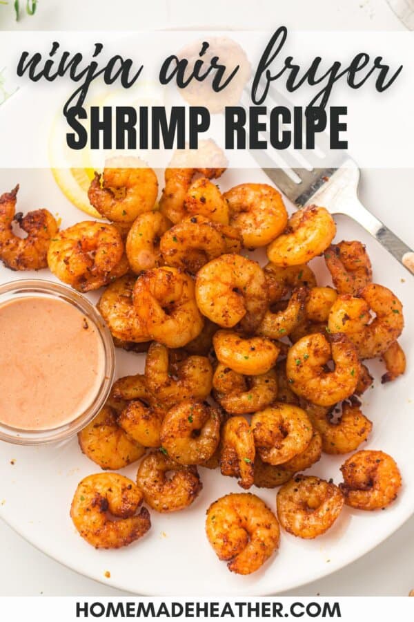 Seasoned shrimp on a white surface with a bowl of spicy mayo.