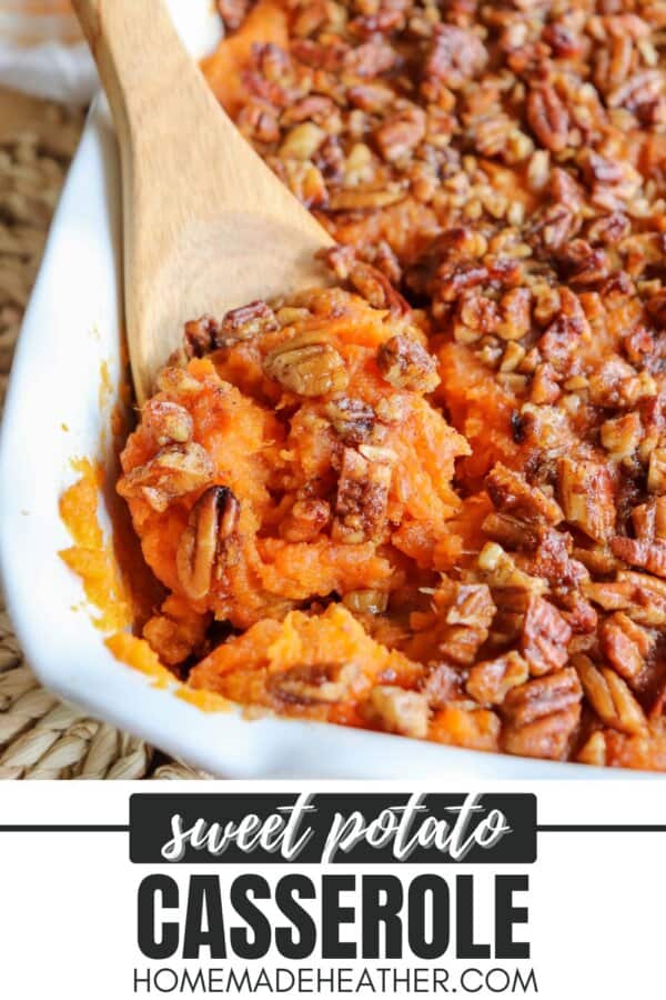Sweet potato casserole topped with a caramel pecan streusel in a white casserole dish with a wooden spoon scooping out some of the mixture.