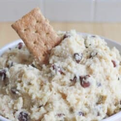 Cookie dough in a white bowl with a graham cracker sticking out.
