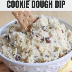 Cookie dough in a white bowl with a graham cracker sticking out.