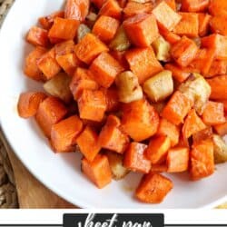 Cooked sweet potato and apple cubed covered in cinnamon in a large white bowl.