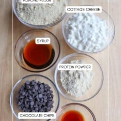 Cottage cheese cookie dough ingredients in clear glass bowls on a wooden table.
