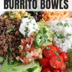 Large white bowl filled with cooked ground taco beef, rice, pico, corn, beans, cheddar cheese and cherry totmatoes, topped with guacamole and sour cream.