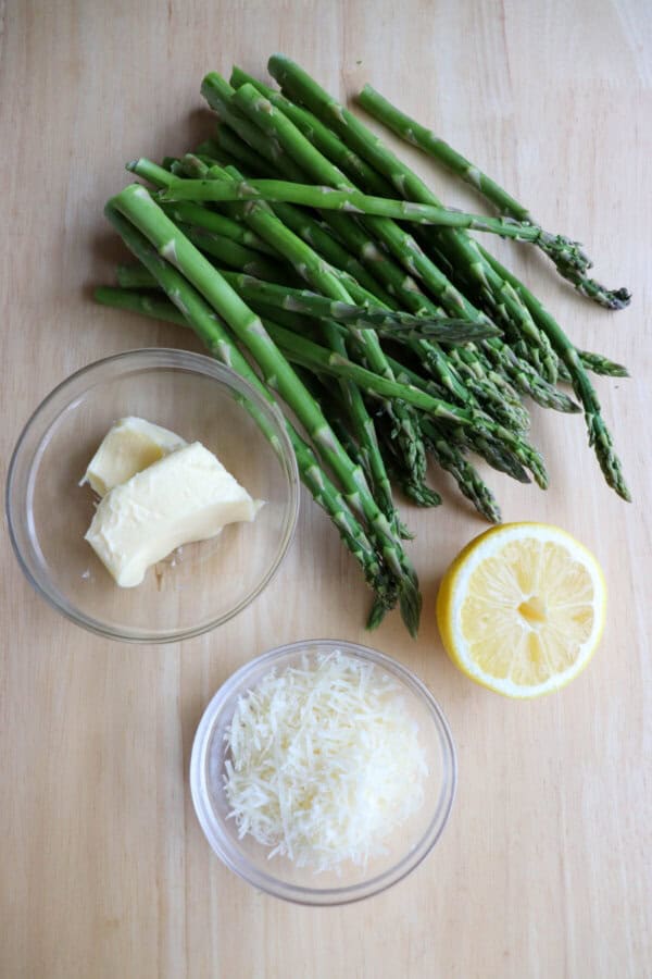 Ingredients doe asparagus foil packs on a wooden table.
