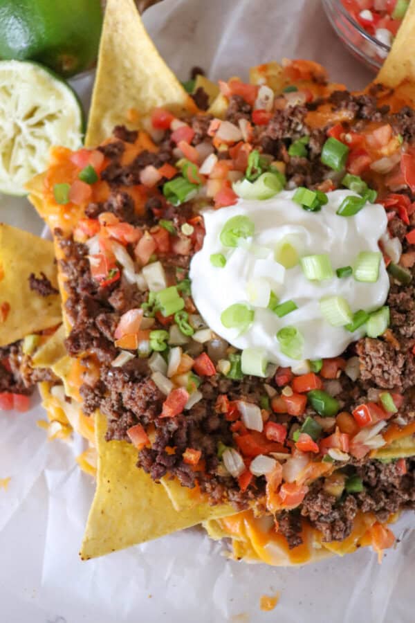 Nachos piled high with taco meat, picco, salsa and green onions.