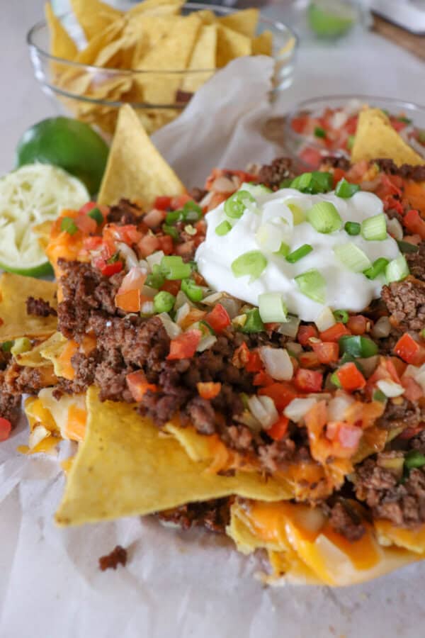 Nachos piled high with taco meat, picco, salsa and green onions.
