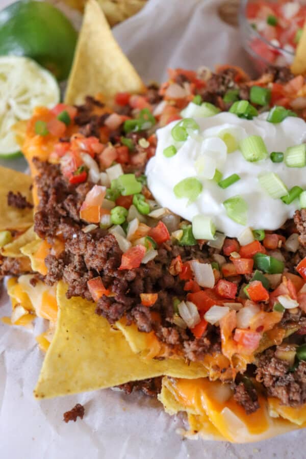 Nachos piled high with taco meat, picco, salsa and green onions.