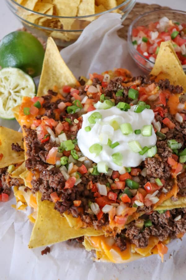 Nachos piled high with taco meat, picco, salsa and green onions.
