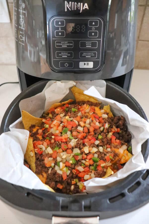 Air fryer nachos in the basket of an air fryer.