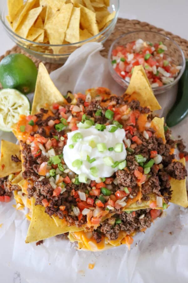Nachos piled high with taco meat, picco, salsa and green onions.