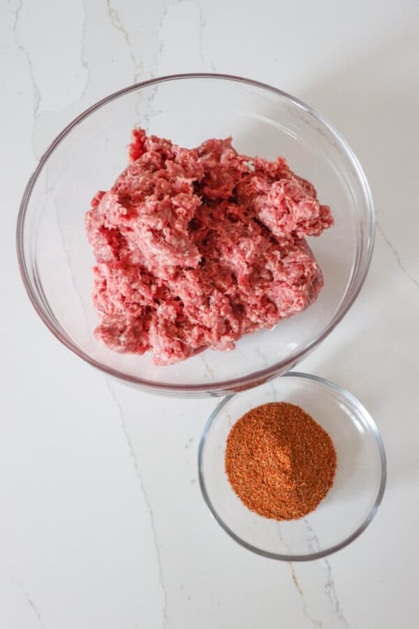 Air Fryer Taco meat ingredients in clear glass bowls on a white counter.