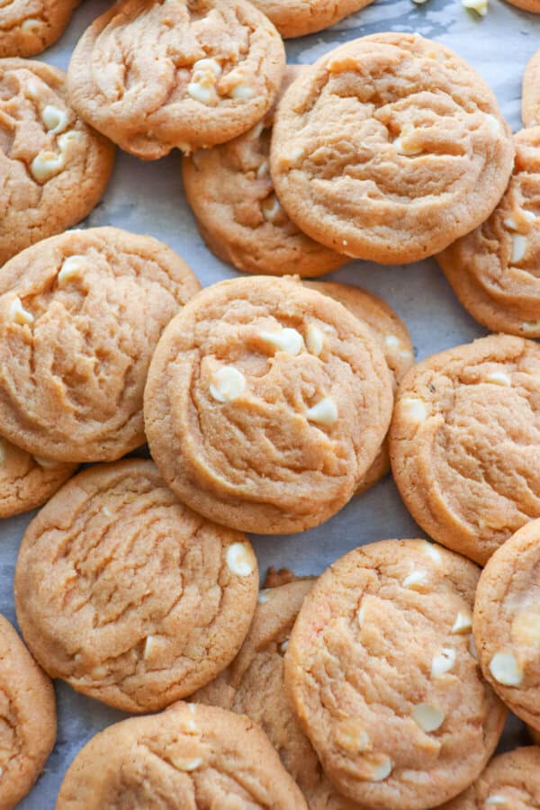 Butterscotch pudding cookies layered on a parchment paper lined cookie sheet.
