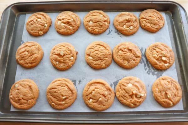 Baked butterscotch cookies on a parchment paper lined cookie sheet.