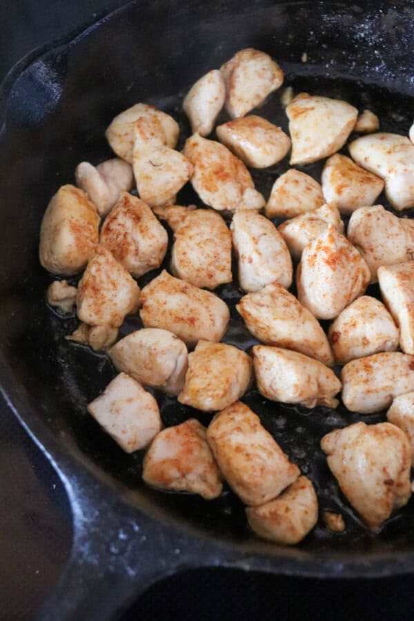 Cooked, diced chicken breast in a cast iron skillet.