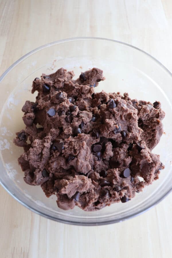 Chocolate pudding cookie dough in a clear glass bowl.