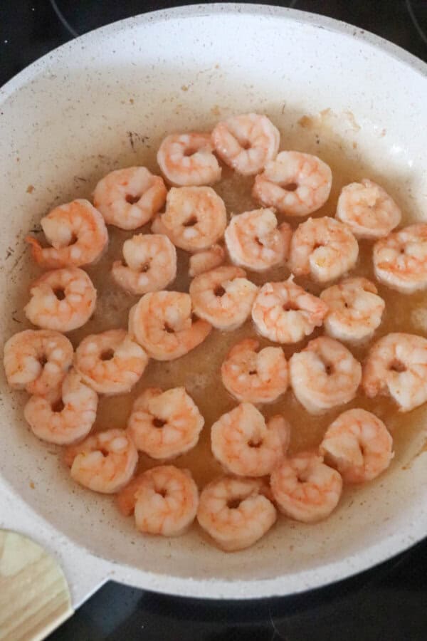Cooked shrimp in a white skillet.