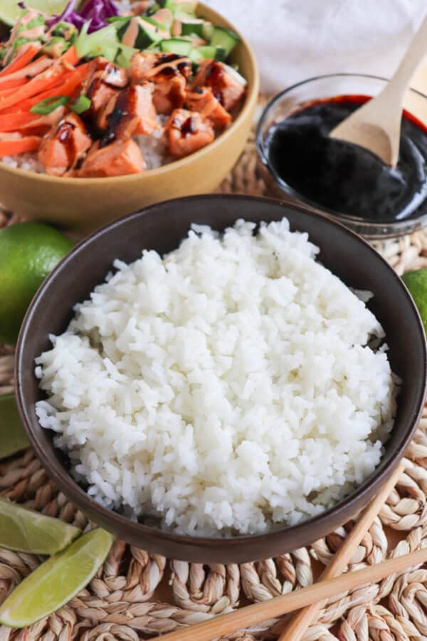 Cooked white rice in a black bowl.