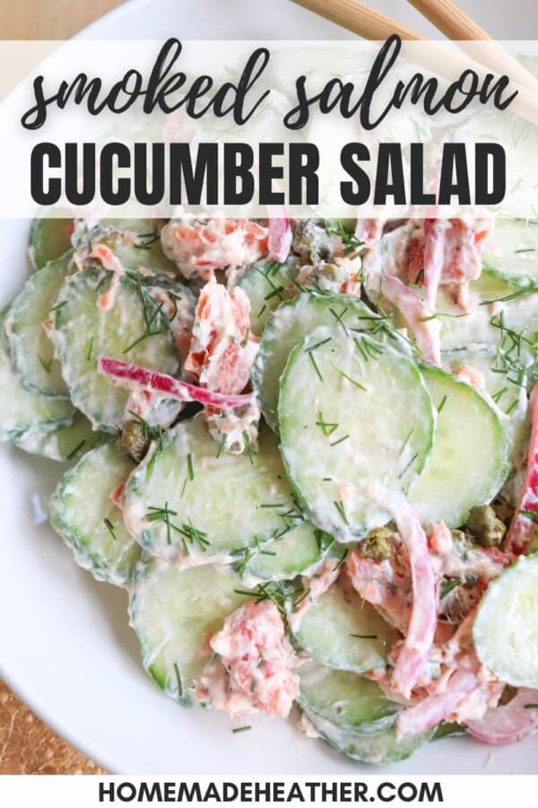 Sliced cucumbers with pieces of smoked salmon and pickled onions covered in a creamy dill sauce in a white bowl.