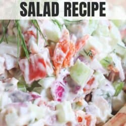 Diced celery, red onion and smoked salmon covered in creamy white mayonnaise in a clay bowl with a sprig of fresh dill on top.