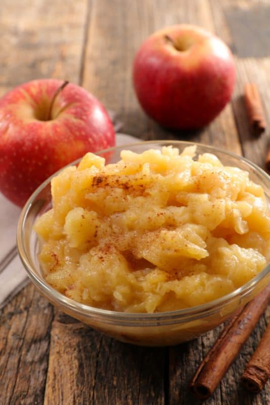 Apple Sauce Apple sauce in a white bowl on a wooden table.