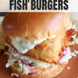 Fried fish filet on a brioche bun with coleslaw and tartar sauce on an orange plate.