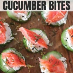 Small rounds of cucumber slices topped with cream cheese, smoked salmon and garnished with fresh dill and lemon zest on a wooden cutting board.