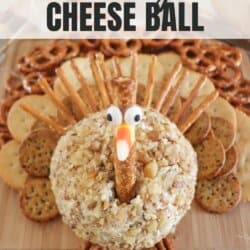 Cheeseball in the shape of a turkey on a wooden cutting board.