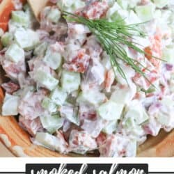 Diced celery, red onion and smoked salmon covered in creamy white mayonnaise in a clay bowl with a sprig of fresh dill on top.