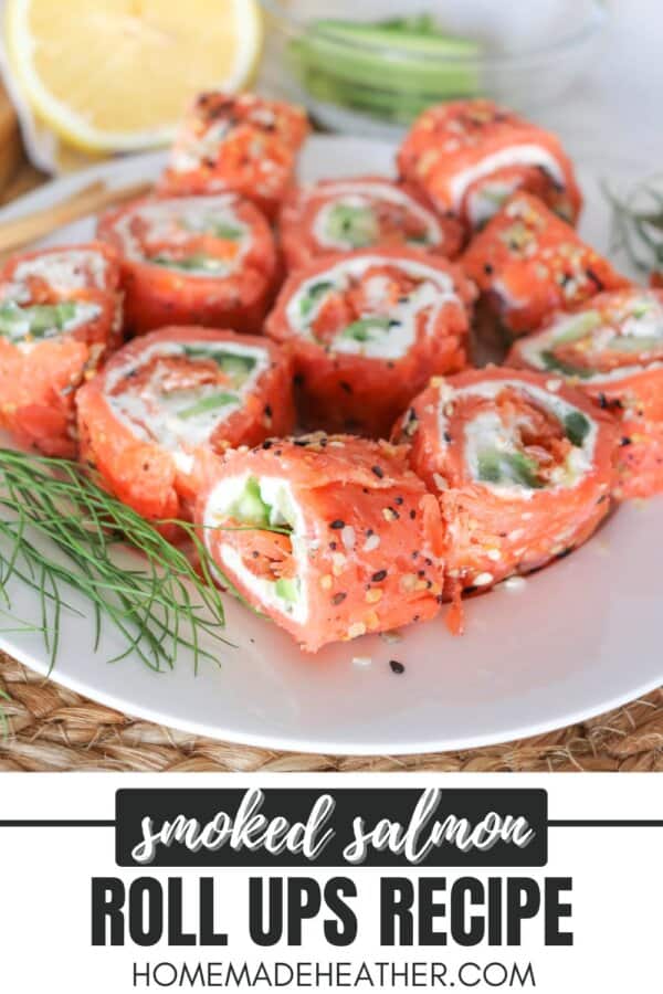Smoked salmon rolled around cream cheese, cucumbers and avocado and cut into sushi style rolls on a white plate.