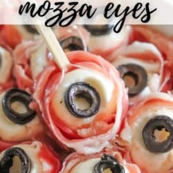 Mozzarella balls wrapped in prosciutto with black olive eyes in a white bowl.