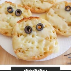 Rounds of garlic toast with two olive eyes and melted cheese.