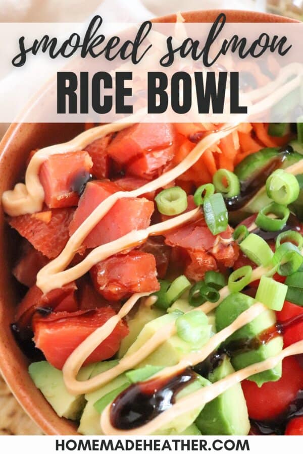 An orange bowl filled with smoked salmon, shredded carrots, cucumber slices, cherry tomatoes, avocado, green onions, and drizzled with sauces, creating a visually appetizing and healthy dish.