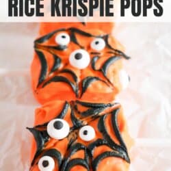 Rice krispie squares covered in orange chocolate with black icing spiderweb and candy eyes.