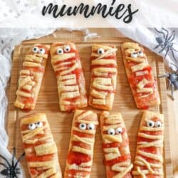 Crescent roll dough in the shape of mummies with candy eyes.