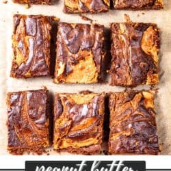 Chocolatey brownies with peanut butter swirls, cut into squares on parchment paper.
