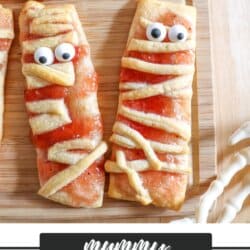 Crescent roll dough in the shape of mummies with candy eyes.