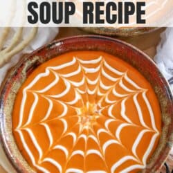 Tomato soup with sour cream in a spiderweb shape on top.