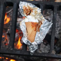 Sugar cone topped with chocolate and marshmallows wrapped in foil.
