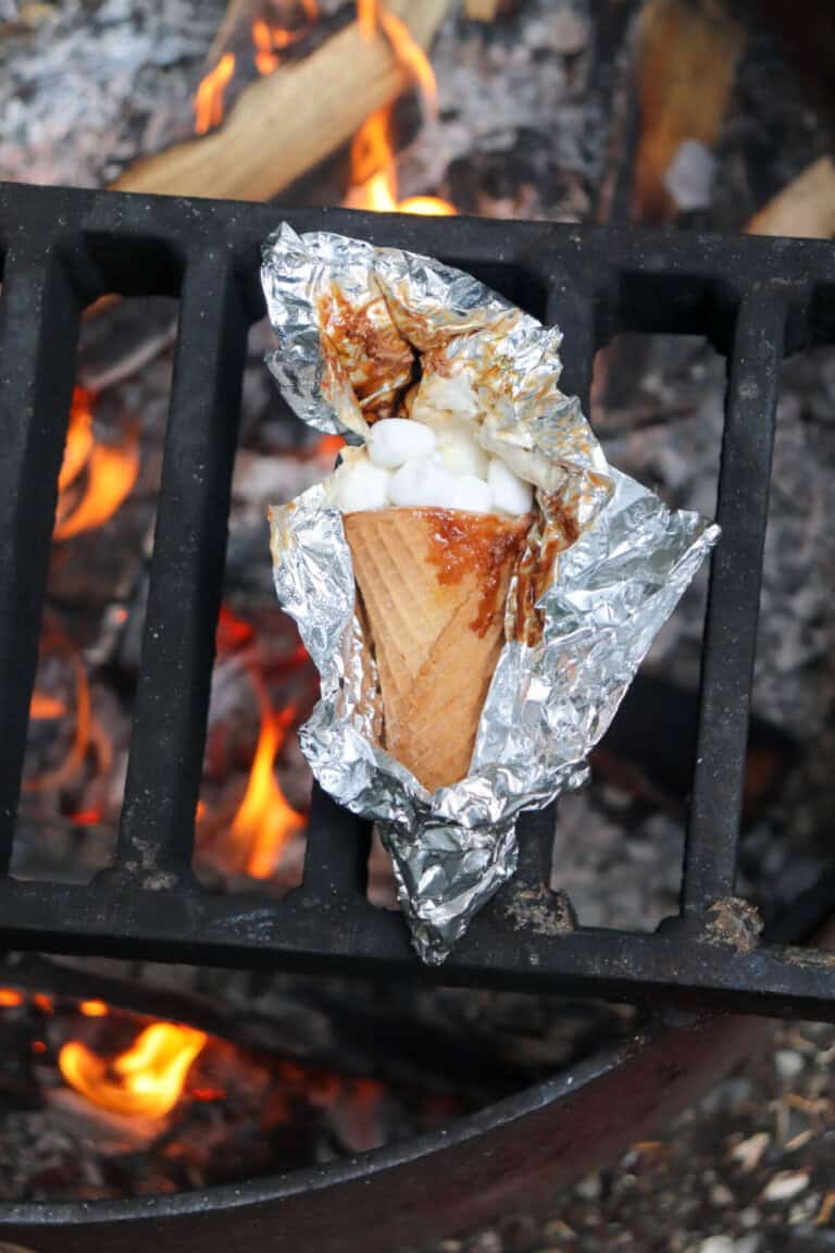 Sugar cone topped with chocolate and marshmallows wrapped in foil.